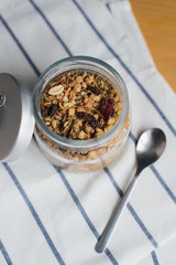 baked muesli with peanuts, hazelnuts, oat and wheat flakes in glass bowl
