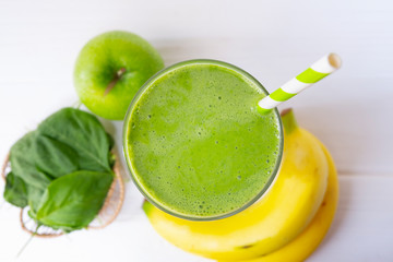 Banana spinach smoothies juice and green juice beverage healthy the taste yummy In glass for milkshake on wooden background from the top view.
