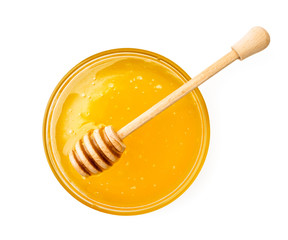 Plate of honey with a wooden stick on a white background. The view of the top.