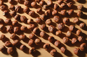 Peeled hazelnuts scattered on a wooden table. Unroasted hazelnut.