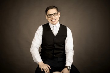 Obraz premium Photography in the Studio. A young man with glasses, wearing a shirt and a vest.