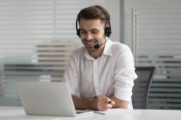 Smiling business man wearing wireless headset make conference video call