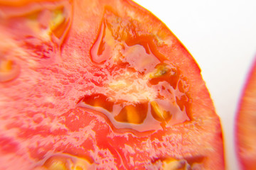 Primer plano de medio tomate, abierto por la mitad, en el que se ven las semillas