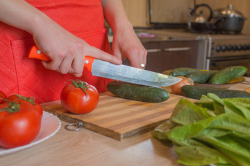 woman hands cutting vegetables on kitchen blackboard. Healthy food. Woman preparing vegetables, cooking healthy meal in the kitchen