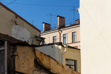 Fototapeta na wymiar variety of roofs and walls of urban residential buildings. view of the old facades below. Saint-Petersburg, Russia