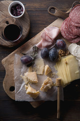 Cheese and meat board, snacks for wine with walnuts and honey