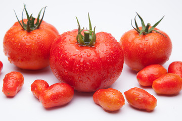 Tomates maduros y tomates cherry juntos en la misma foto. Foto de conjunto de tomates saludables y sanos, hay tomates grandes y tomates cherry