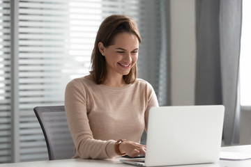 Happy young business woman employee using computer working in office
