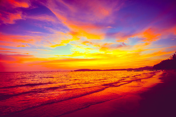 Amazing fairy tale colorful sunset over the calm ocean surface next to the exotic tropical islands...