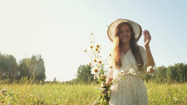 Woman with flowers in the field at morning