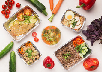 Foil containers with healthy food on white background