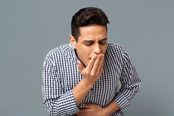 Man Feeling Sick And Nauseous On Gray Background