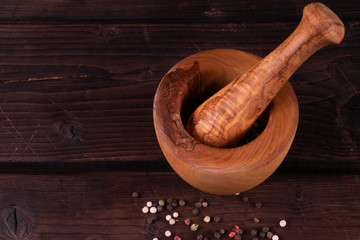Obraz na płótnie Canvas wooden mortar with pepper, low key, olive wood, rustic