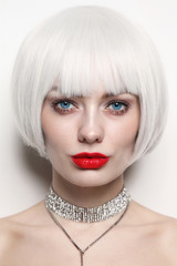 Vintage style portrait of young beautiful woman with platinum blonde hair and red lips