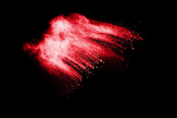 Abstract red dust splattered on white background. Red powder explosion.Freeze motion of red particles splashing.