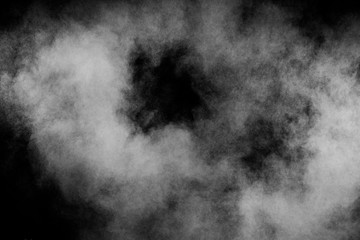 Abstract white powder explosion against black background.White dust cloud in the air.