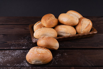 Buns in bread basket on a wooden background, low key