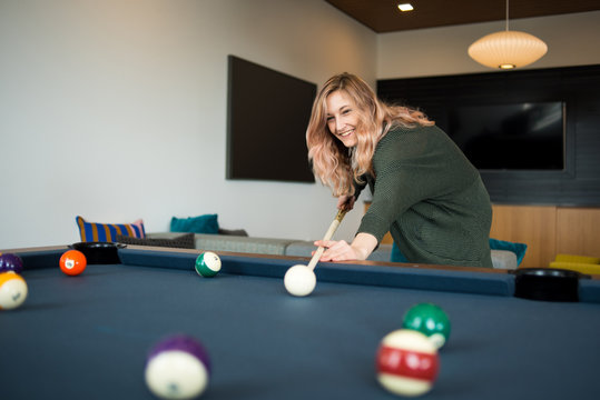 Woman preparing to take her shot during game of pool
