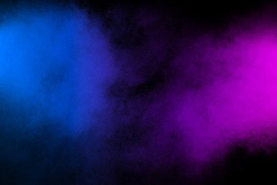 Pink blue powder explosion on black background.Pink blue dust splash cloud on dark background.