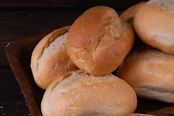 Buns in bread basket on a wooden background, low key