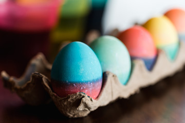 Close up of dyed Easter eggs in bright colors drying in a carton.