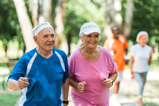 selective focus of happy retired couple exercising outside