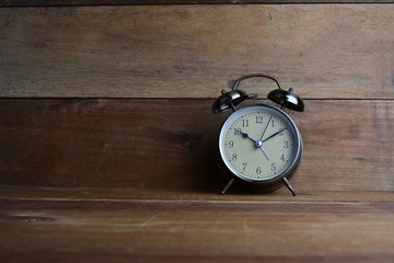 Retro alarm clock on wood background