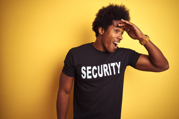American safeguard man with afro hair wearing security uniform over isolated yellow background very...