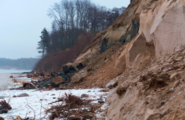 Steep coast of the sea. Landslides and destruction to the shores of the sea.