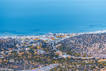 Fototapeta premium Top view from the autumn mountains to the village of Malia, roads and the nearby villages of the field and the Aegean Sea. Crete, Greece