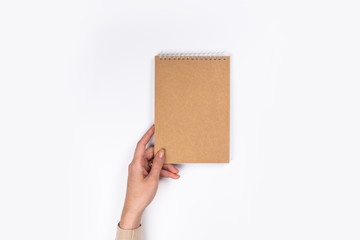 Woman's hands with perfect manicure holding notepad as mockup for your design. White background, flat lay style.