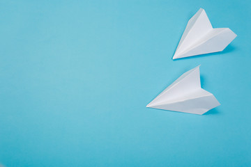 white paper airplane on a navy paper background