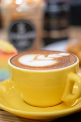 coffee latte art in the yellow coffee cup