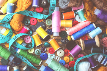 Sewing tool for needlework, colored threads centimeter and buttons with a pair of scissors on the table. close-up.