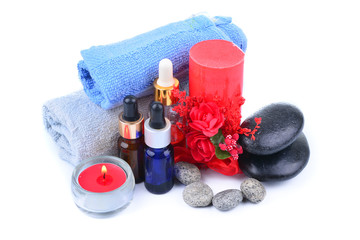 Obraz na płótnie Canvas Red romantic candle and spa oil with towel and zen stone isolated on white background