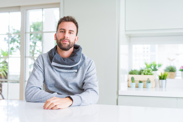 Handsome man at home with serious expression on face. Simple and natural looking at the camera.