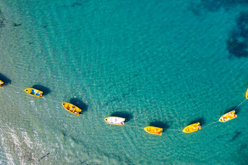 Obraz premium Aerial view of boats floating on calm sea water. Turquoise ocean seen from above.