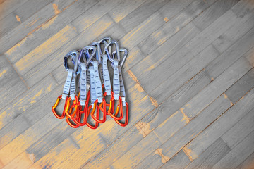 Multiple quickdraws in a stack, laid out on dark wooden background. Space for text on the right....