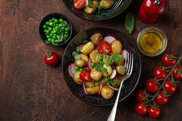 baby potatoes salad with tomato, green peas and radish