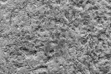 black-and-white background of a gray ancient wall , texture of an old rough stone
