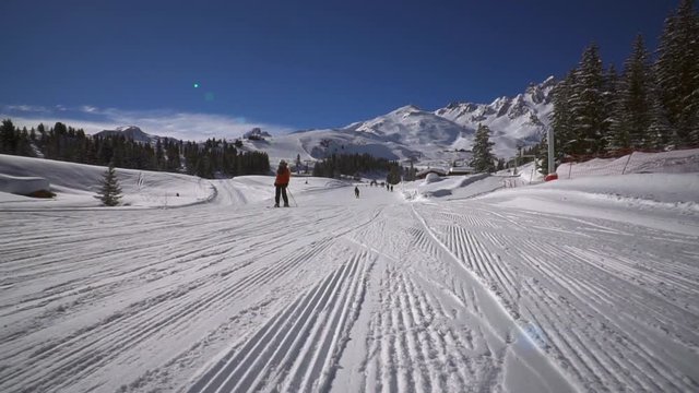 Courchevel France 02.2022: Winter holidays. Snow-covered coniferous forests. Cabins lift on a cable car lift tourists to the tops of snow-capped mountains in the Alps. Freezing sun day Resort
