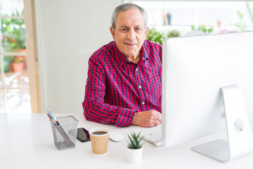 Handsome senior man working using computer and smiling confident
