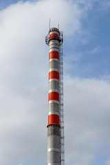 Thick white smoke from a high industrial plant chimney