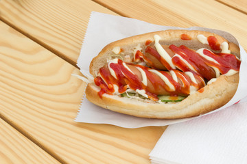 Fast food concept: hot dog with two sausages and ketchup on the table. Top view