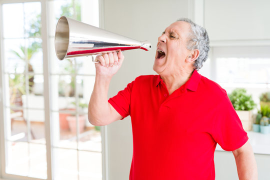 Senior man shouthing excited through vintage metal megaphone