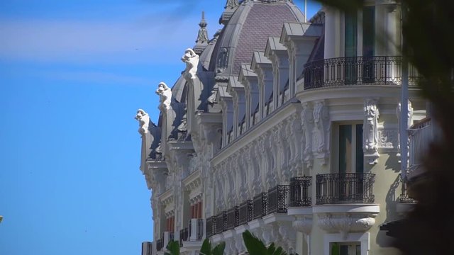 Monaco, Monte Carlo. The road leading from the casino to the port. In the frame are visible buildings and the blue sea in the background. On the road going car. The pattern of the city.