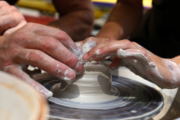 Master of ceramics. We work with clay. The master ceramist teaches the student. Craftsman hands sculpts clay