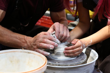 Master of ceramics. We work with clay. The master ceramist teaches the student. Craftsman hands sculpts clay