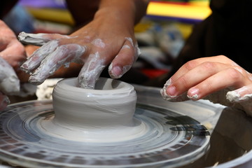 Master of ceramics. We work with clay. The master ceramist teaches the student. Craftsman hands sculpts clay