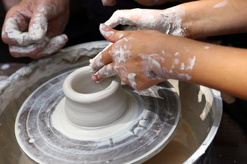 Master of ceramics. We work with clay. The master ceramist teaches the student. Craftsman hands sculpts clay